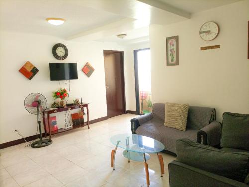 ein Wohnzimmer mit einem Sofa und einem Tisch in der Unterkunft Enjoy the City View! in Manila