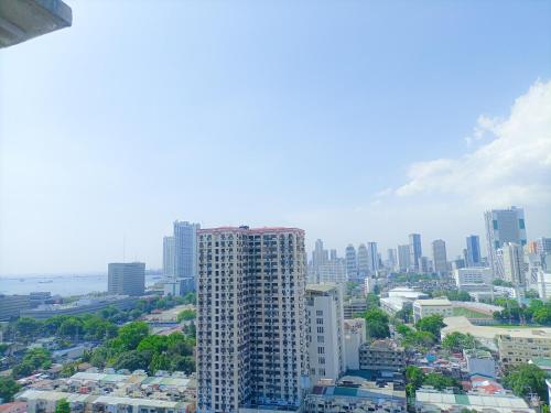Blick auf eine Stadt mit einem hohen Gebäude in der Unterkunft Enjoy the City View! in Manila