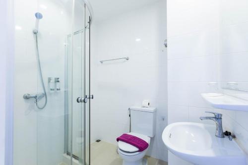 a bathroom with a shower and a toilet and a sink at Hotel Zing in Pattaya South