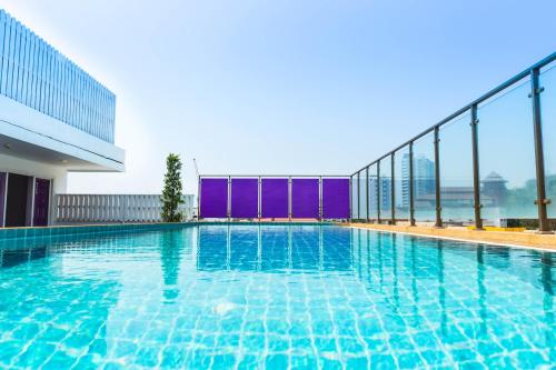 a swimming pool on the roof of a building at Hotel Zing in Pattaya South