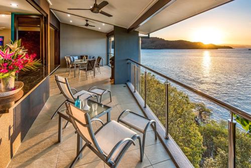 a balcony with a table and chairs overlooking the water at Edge Apartments on Hamilton Island by HIHA in Hamilton Island