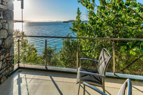 a chair on a balcony with a view of the water at Edge Apartments on Hamilton Island by HIHA in Hamilton Island