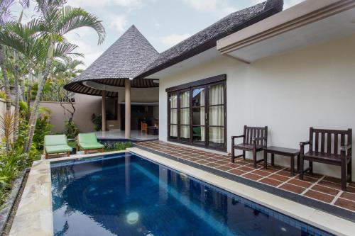 a villa with a swimming pool and a house at The Bidadari Villas and Spa Umalas - CHSE Certified in Canggu