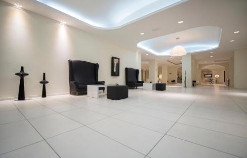 a waiting room with black chairs and a white tile floor at Golden Beach in Hersonissos