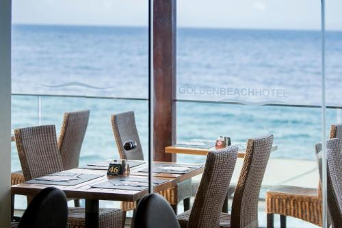 uma mesa e cadeiras com o oceano ao fundo em Golden Beach em Hersonissos