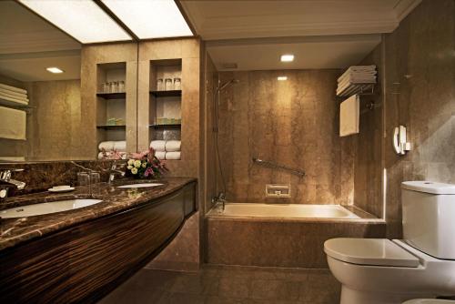 a bathroom with a tub and a toilet and a sink at York Hotel in Singapore