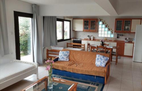 a living room with a couch and a kitchen at Dora's House comfortable apartment with a yard and view in Pyrgadikia