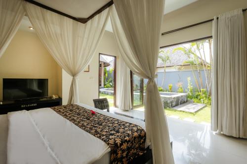 a bedroom with a bed and a large window at The Bidadari Villas and Spa Umalas - Seminyak in Canggu