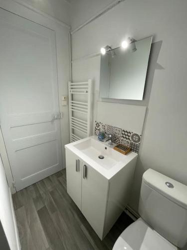 une salle de bain blanche avec des toilettes et un lavabo dans l'établissement Cosy & Clim Parfait jusqu'à 6 voyageurs bus gare shopping centre, à Béziers