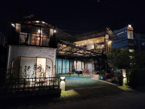 a house with a swimming pool at night at Capital O 75422 Million Pillows in Chiang Mai