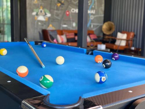 a pool table with a cue and balls on it at Capital O 75422 Million Pillows in Chiang Mai