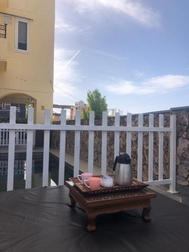 a table with a tea pot and cups on a balcony at Jai Villa Homestay in Udaipur
