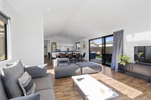a living room with a couch and a dining room at Wanderlust - Queenstown Holiday Home in Queenstown