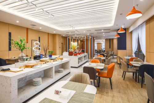 a dining room with tables and chairs and a restaurant at Holiday Inn Express Chongqing Guanyinqiao , an IHG Hotel in Chongqing