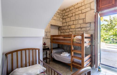 2 stapelbedden in een kamer met een stenen muur bij Casale Della Contea in Casa Papa