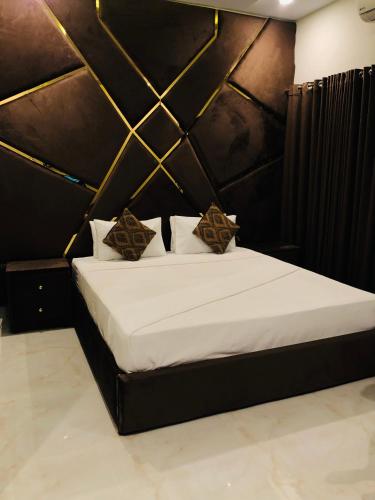 a bedroom with a large bed with a black wall at Star House in Islamabad