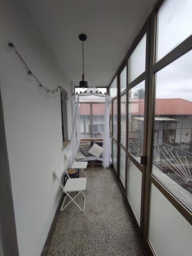 een balkon met een witte stoel en ramen bij The Loft in Koper
