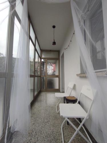 een kamer met 2 witte stoelen en ramen bij The Loft in Koper