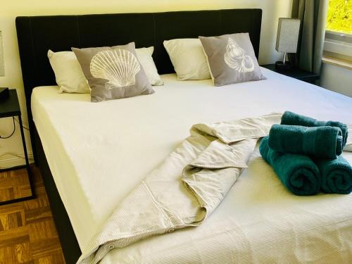 a white bed with towels on it with at FeWo MEERESBRISE - Familie- Hunde - Strandnah - Garten-Seeblick - Sauna & Wellness in Sierksdorf