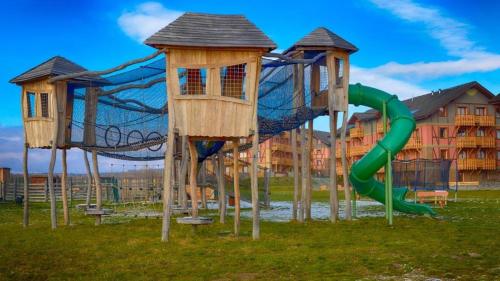 un parque infantil con un tobogán y dos estructuras de juego en Hill View Apartment Tatragolf, en Veľká Lomnica