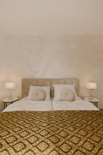 a bedroom with a bed with two lamps on two tables at Hill View Apartment Tatragolf in Veľká Lomnica