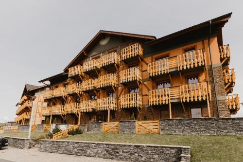 ein Gebäude mit Holzbalkonen auf der Seite in der Unterkunft Hill View Apartment Tatragolf in Veľká Lomnica