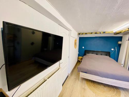a bedroom with a large flat screen tv on a wall at Jolie chambre indépendante in Limoges