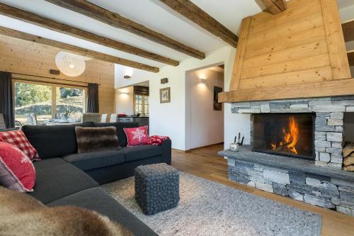 a living room with a couch and a fireplace at Chalet Grand Roi in La Tzoumaz