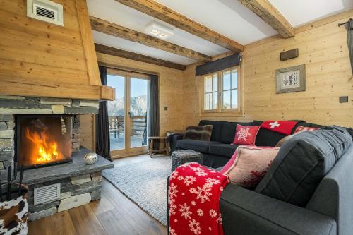 a living room with a couch and a fireplace at Chalet Grand Roi in La Tzoumaz