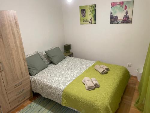 1 dormitorio con 1 cama con 2 zapatillas en Pokoje do wynajęcia - Podwisłocze 8a en Rzeszów