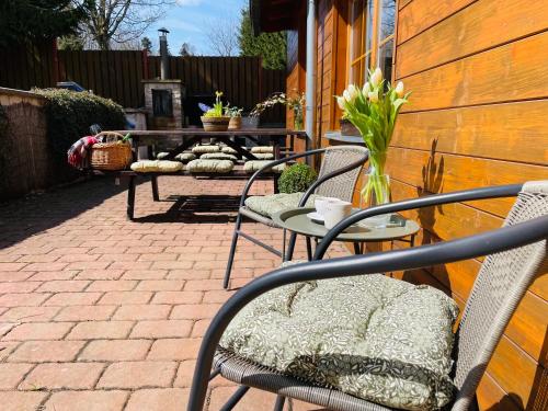 a patio with two chairs and a table with flowers at Apartmán na sjezdovce in Sedloňov