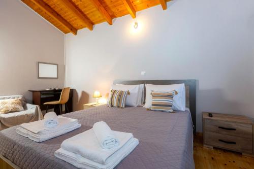 ein Schlafzimmer mit einem Bett mit Handtüchern darauf in der Unterkunft Vitos Village House in Ágios Matthaíos