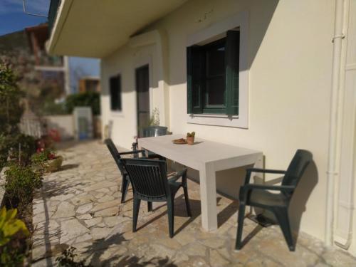 una mesa blanca y sillas en un patio en Perfetto Country House - Myrtos View en Anomeriá