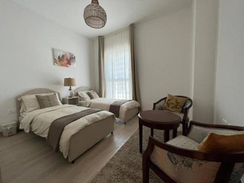 a bedroom with two beds and a table and a chair at Best deal in town Yas Island 232WB10 in Abu Dhabi