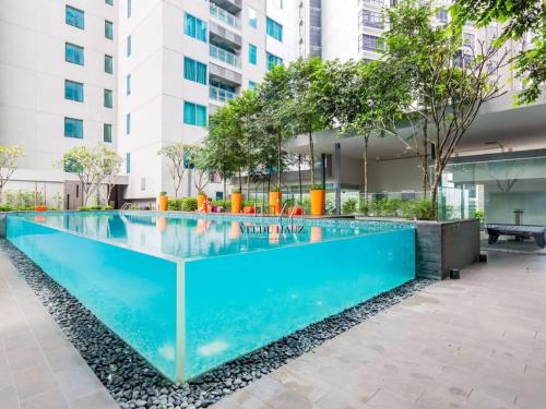 uma piscina no meio de um edifício em Mercu Summer Suites KLCC by Veedu Hauz em Kuala Lumpur