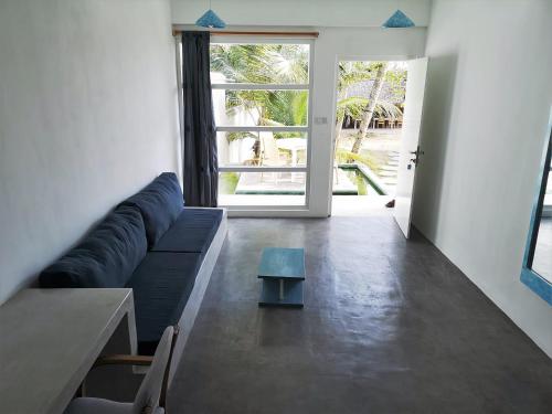 ein Wohnzimmer mit einem blauen Sofa und einem Tisch in der Unterkunft NAVA b&b in Mirissa