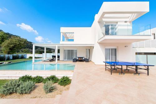 una villa moderna con piscina e tavolo di Villa Odysseas a Ialyssos