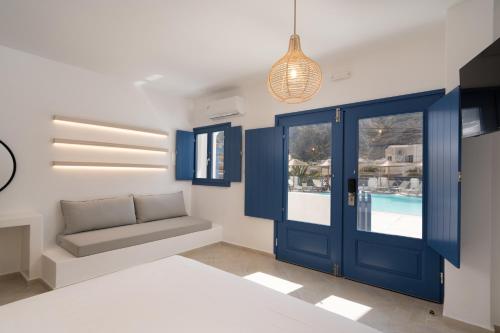 a bedroom with a blue door and a couch at Hotel Sunshine in Kamari