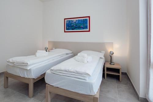 2 Einzelbetten in einem Zimmer mit einem Tisch in der Unterkunft Classic Bardolino Apartment in Bardolino