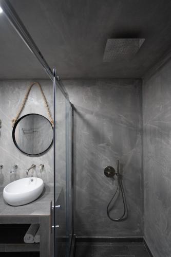 a bathroom with a shower with a sink and a mirror at Hotel Sunshine in Kamari