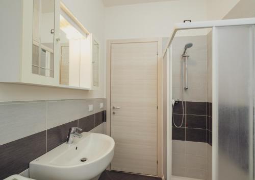 uma casa de banho com um lavatório branco e um chuveiro em Classic Bardolino Apartment em Bardolino