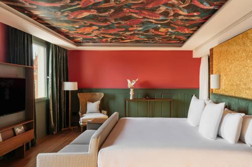 a bedroom with a bed and a painting on the ceiling at Hotel Colón Gran Meliá - The Leading Hotels of the World in Seville