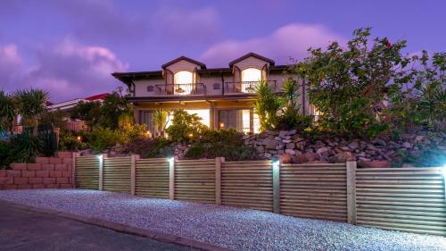 a house with a fence in front of it at night at Pezula Magic Escape - Guest House - No Loadshedding in Knysna