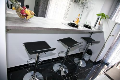 a kitchen with three bar stools under a counter at Chris Luxury Studio in Ioannina
