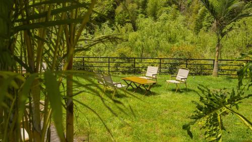 two chairs and a table in the grass at Pandora Vista Retreat in Zhangjiajie