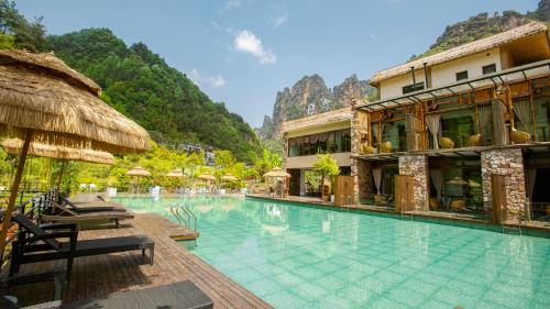 a swimming pool at a resort with mountains in the background at Homeward Mountain Resort in Zhangjiajie