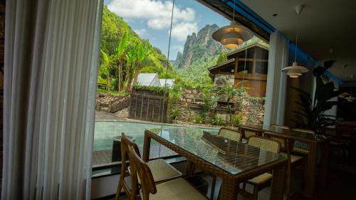 a dining room with a table and a large window at Homeward Mountain Resort in Zhangjiajie