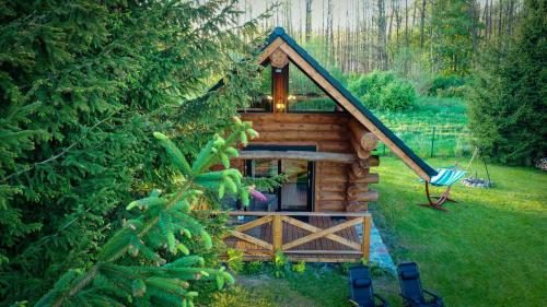 a small log cabin in a yard with a fence at Domek z bala MAZURY, bezpośredni dostęp do jeziora, plaża, pomost in Szczytno