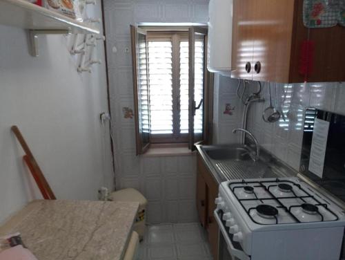 a small kitchen with a stove and a sink at Diamantina Kiss in Diamante