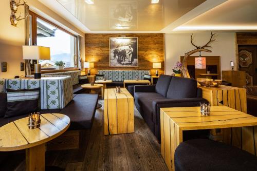 a lobby with couches and tables in a restaurant at Alm- & Wellnesshotel Alpenhof in Schönau am Königssee